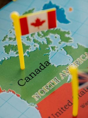 pexels-photo-8828347-8828347 Detailed close-up of a Canadian flag standing on a map of North America, highlighting Canada.